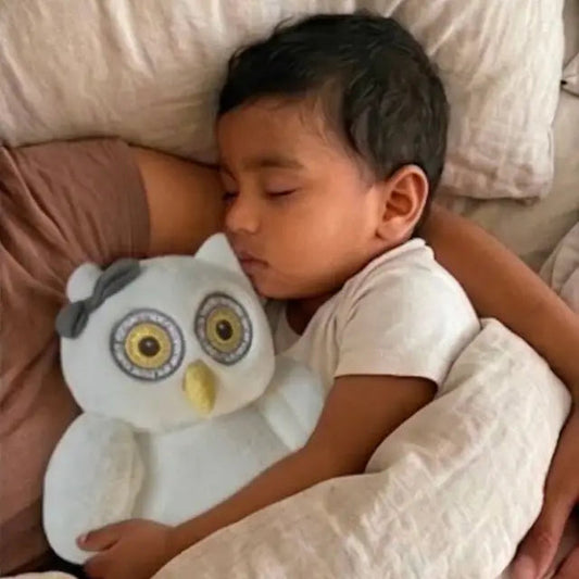 Un bébé endormi avec Oli la chouette