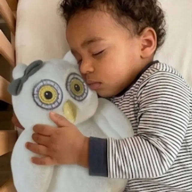 Un bébé endormi avec Oli la chouette