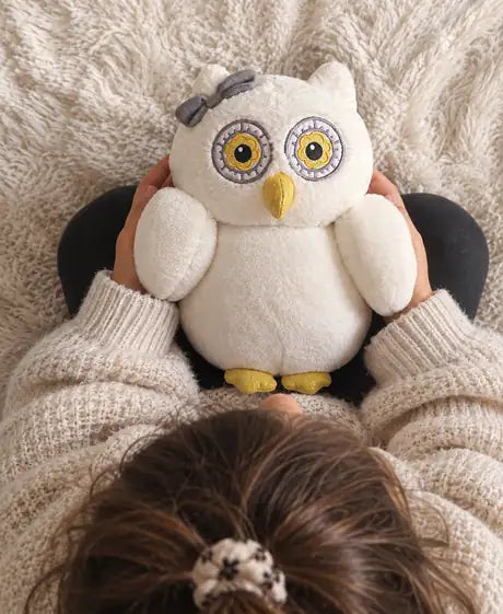 Oli la chouette, peluche d'hypnose douce, tenue dans les bras d'un enfant