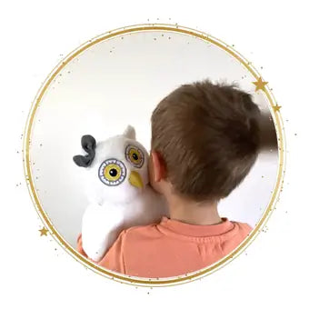 Un enfant fait un câlin à Oli la chouette